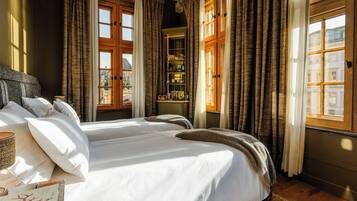 Une chambre à coucher avec un grand lit, une table de chevet, une étagère avec divers objets et une vue sur l’extérieur.