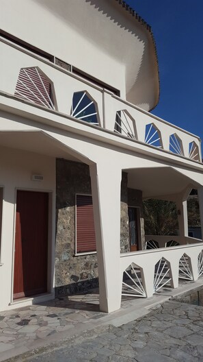 A modern building with a flat roof, large windows, and a stone facade.