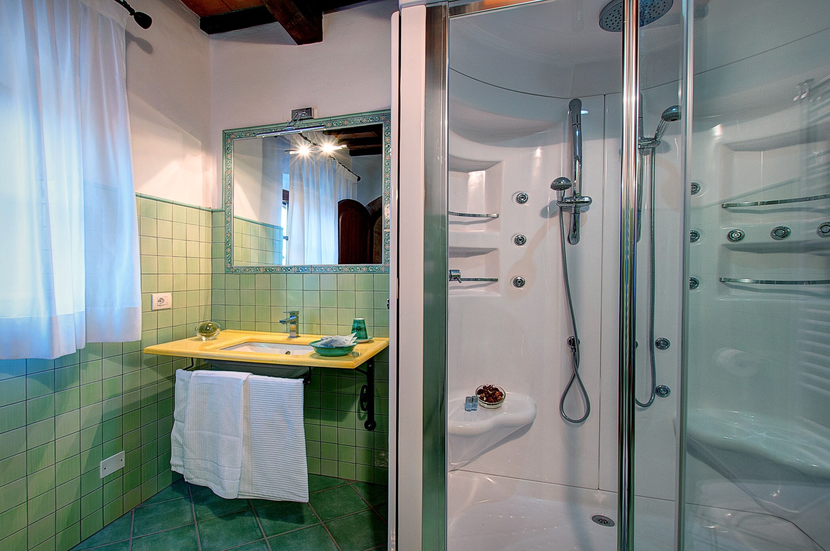 A bathroom with a shower, sink, and mirror.