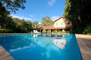 Una piscina al aire libre, sillones reclinables de piscina