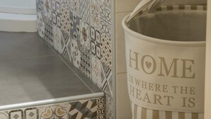 Un salpicadero de azulejos estampados y una cesta de almacenamiento a rayas con el texto 'HOME IS WHERE THE HEART IS'.