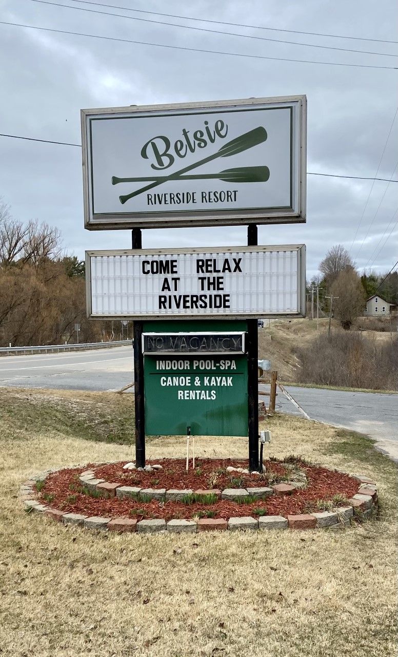A sign for Riverside Resort advertising indoor pool, spa, canoe and kayak rentals.
