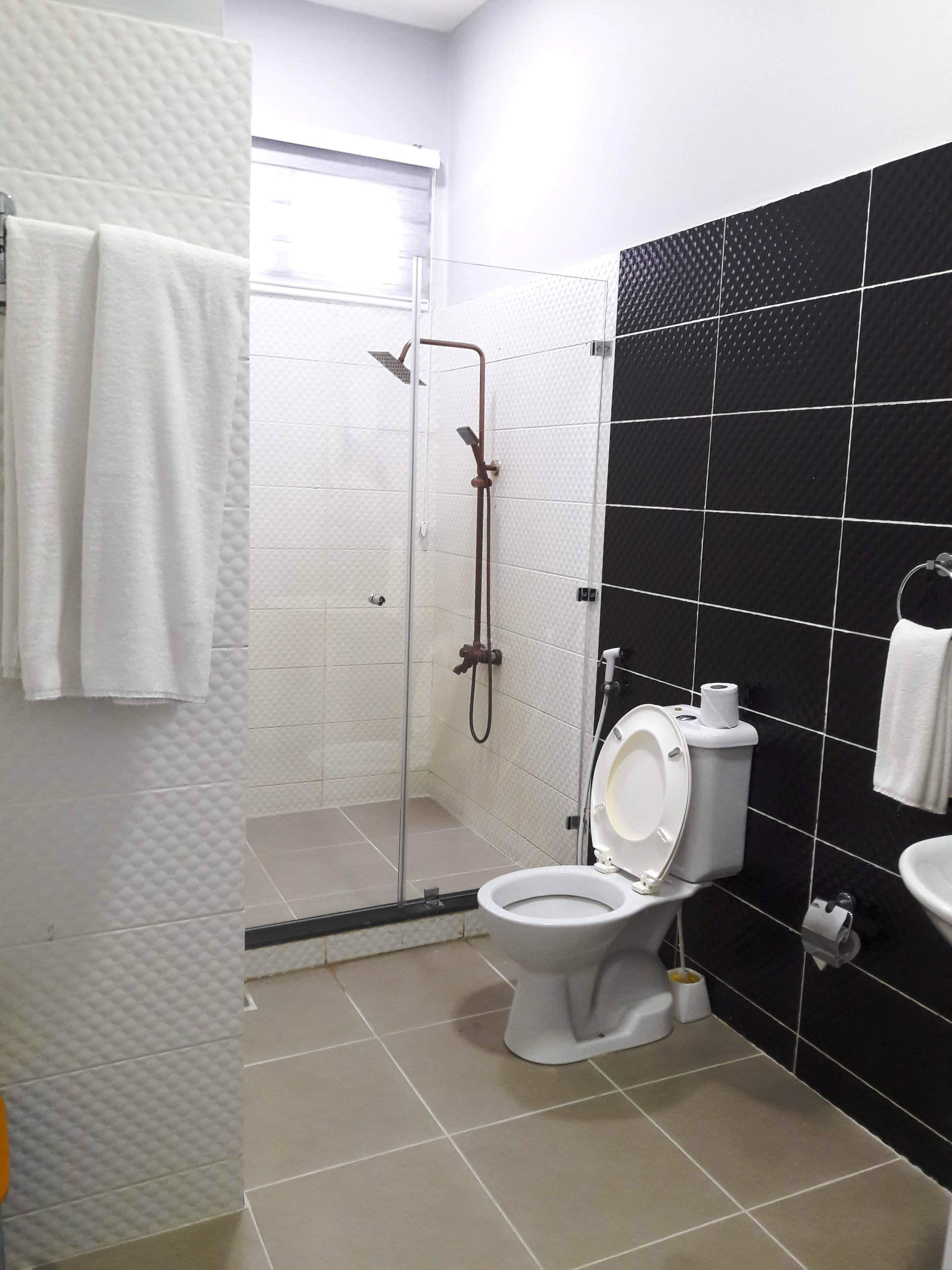 A bathroom with a shower, toilet, and sink.