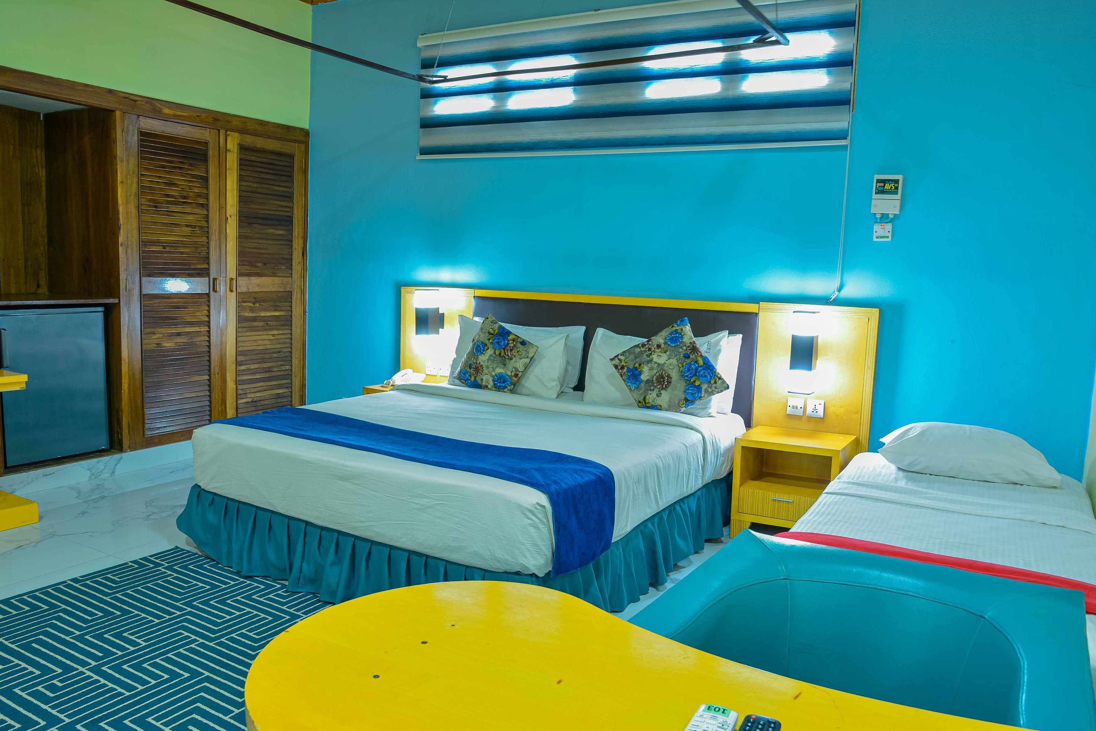 Ein Hotelzimmer mit Bett, Nachttischen, Schreibtisch und Stuhl.