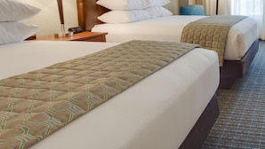 A hotel room with two beds, a headboard, bedside lamps, a clock, and a window with curtains. - Drury Plaza Hotel St. Louis St. Charles (St. Charles)
