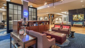 A modern hotel lobby with a reception desk, seating area, and artwork on the walls. - Hampton Inn & Suites Portland-Pearl District (Portland)