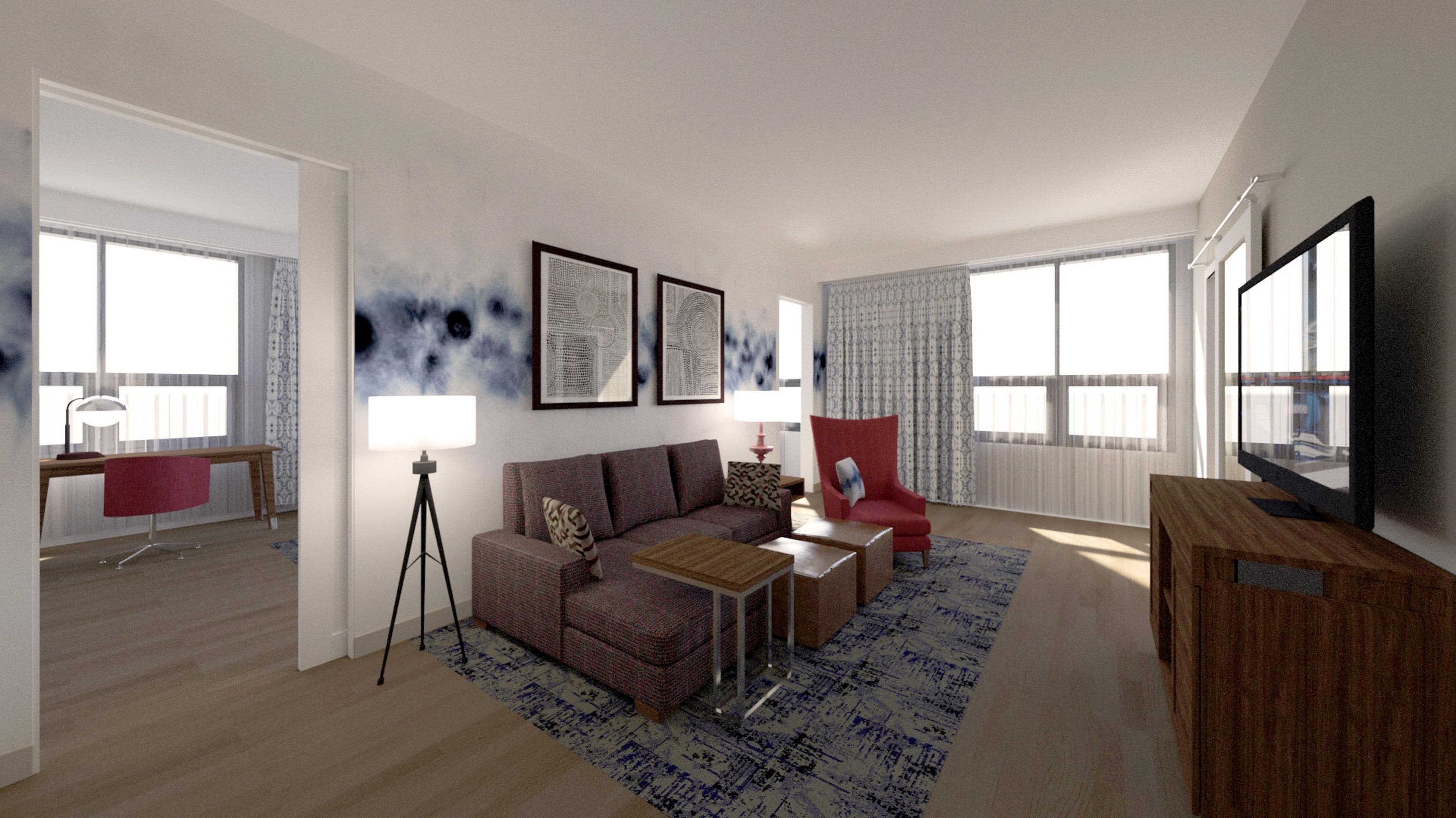 A modern living room with a sofa, armchair, coffee table, and a flat-screen TV.