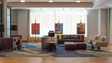 A modern living room with a sofa, armchairs, a coffee table, and artwork on the walls.