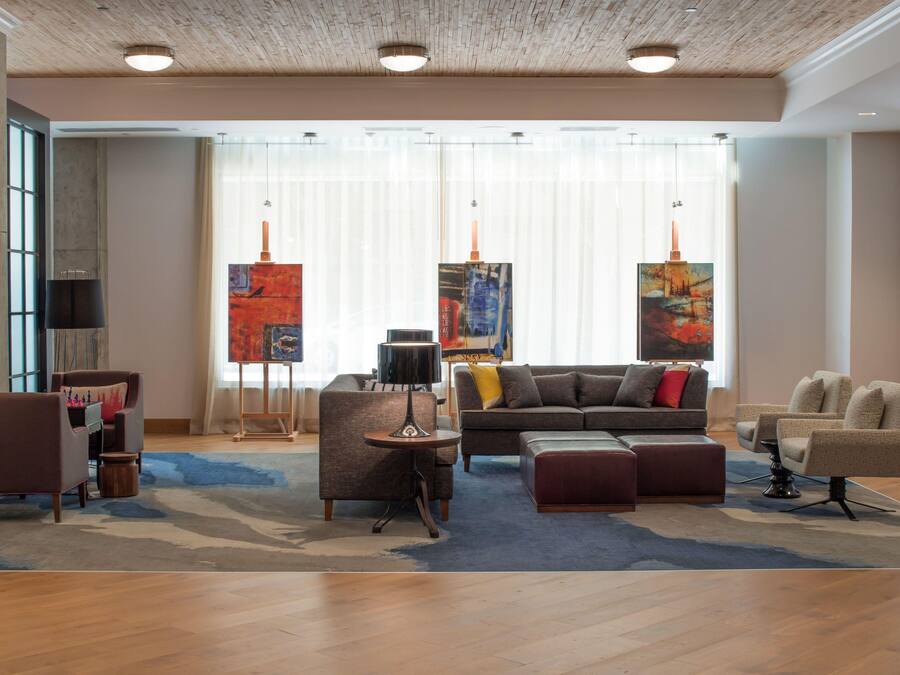 A modern living room with a sofa, armchairs, a coffee table, and artwork on the walls.