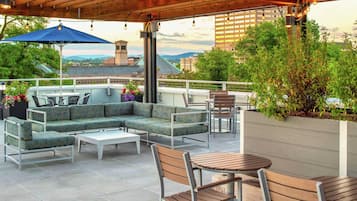 Un patio al aire libre con un sofá modular, una mesa redonda y sillas.