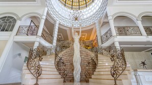 A grand staircase with ornate railings and a central sculpture.