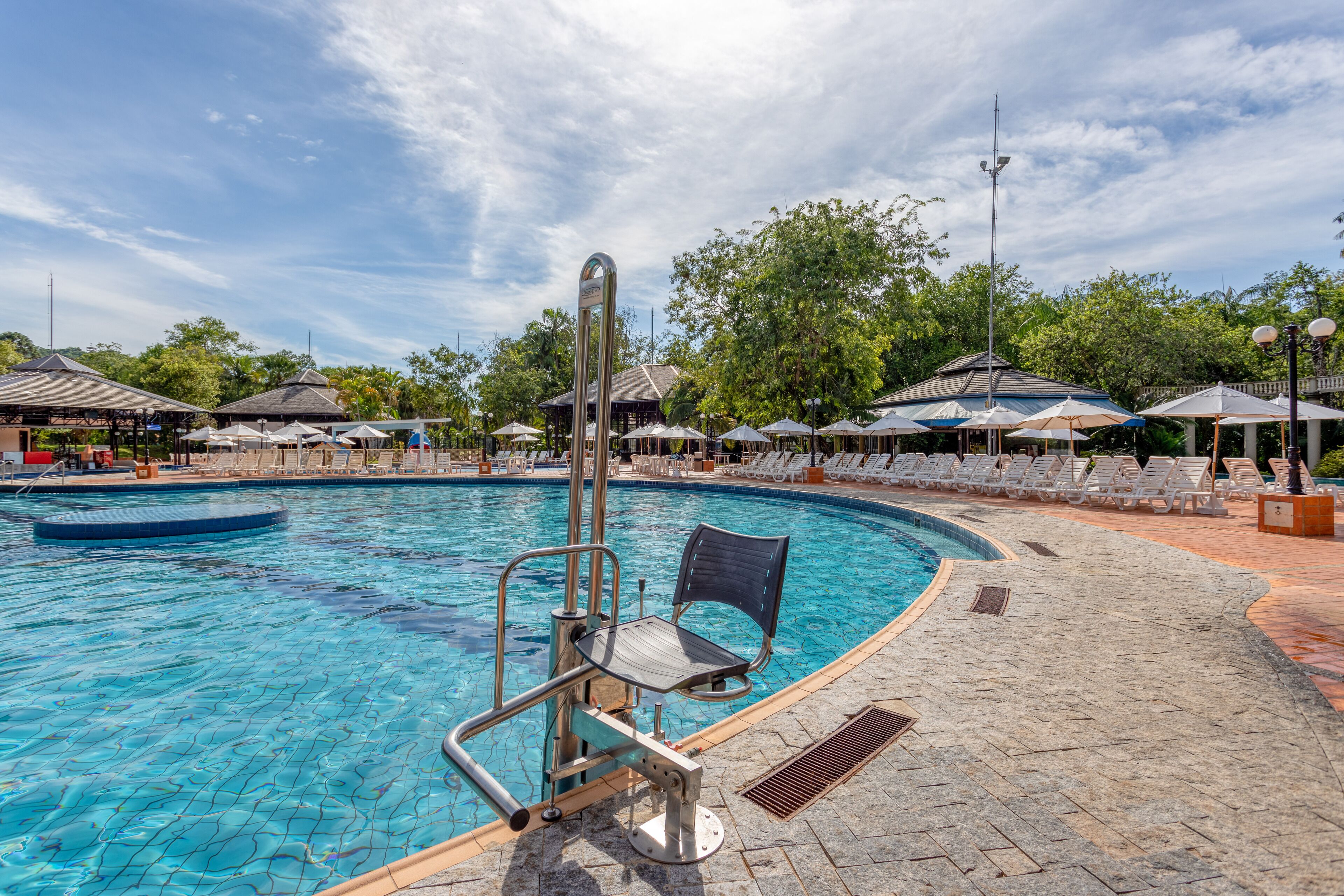 A swimming pool with a lifeguard chair and a diving board.