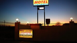 A Budget Inn Motel sign with a vacancy notice and a sign for clean, luxurious rooms.