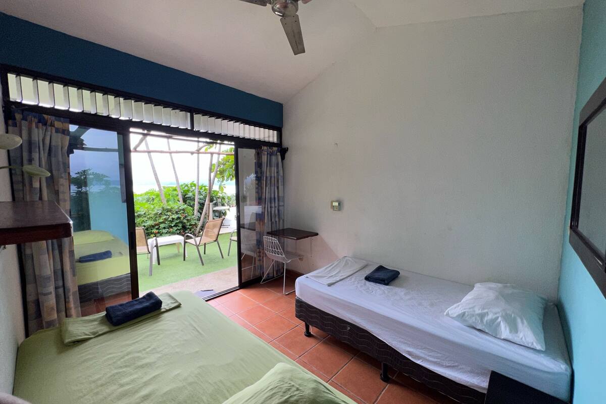 Une chambre à coucher avec un lit, une chaise, une table et une vue sur l’extérieur.