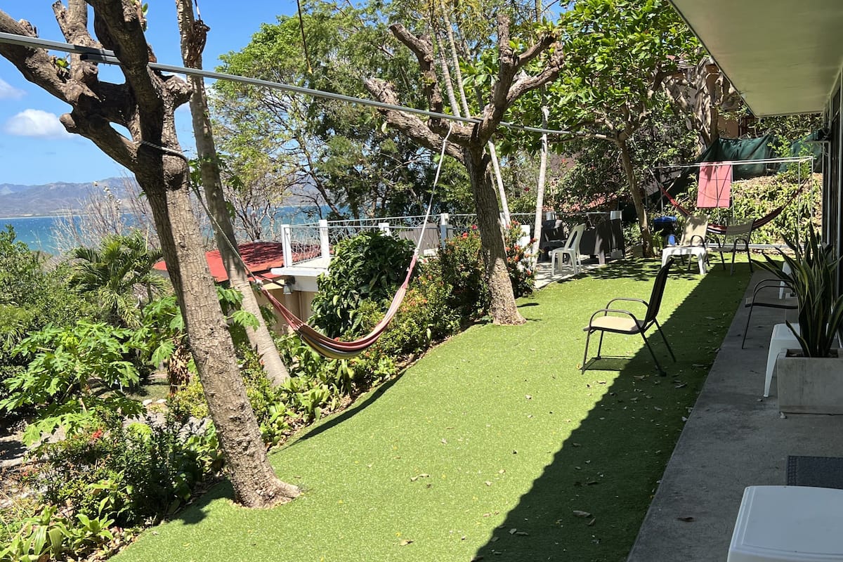 Une terrasse avec un hamac, des chaises et une vue sur l’océan.