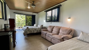 Una habitación moderna con techo de madera, un sofá, una cama y un comedor.