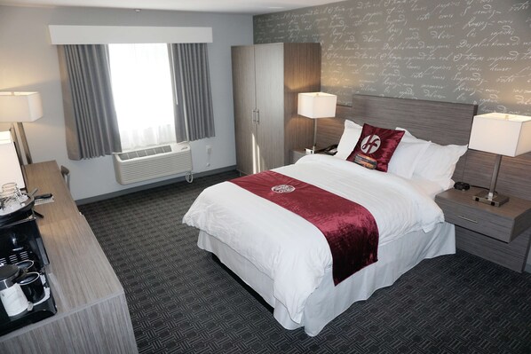 A hotel room with a large bed, a desk with a lamp, a wardrobe, and a window with curtains. - Hartford Hotel, BW Signature Collection (Rosemead)