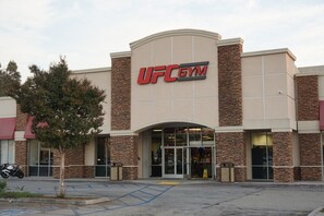 A UFC Gym with a modern design, featuring a prominent entrance and a parking area in front. - Hartford Hotel, BW Signature Collection (Rosemead)