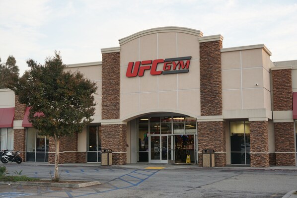 A UFC Gym with a modern design, featuring a prominent entrance and a parking area in front. - Hartford Hotel, BW Signature Collection (Rosemead)