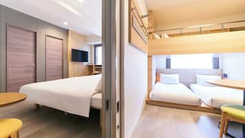 Quarto de hotel moderno com uma cama, uma mesinha e uma televisão.
