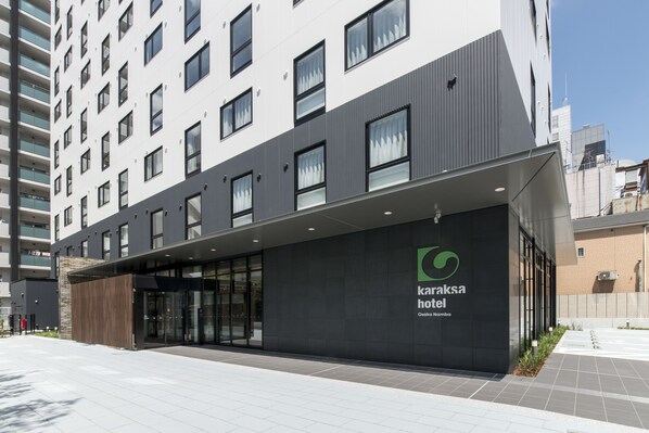 Un hôtel moderne, avec une entrée imposante, de grandes fenêtres et un logo bien visible.