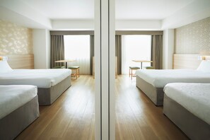 A mirrored hotel room with two beds, a small table, and a chair. - karaksa hotel Osaka Namba (Osaka)