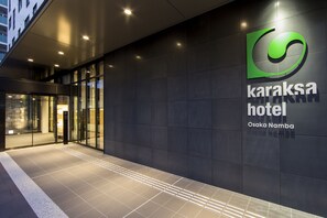 The exterior of the Karaksa Hotel in Osaka Namba, featuring a modern facade with a prominent logo and signage. - karaksa hotel Osaka Namba (Osaka)