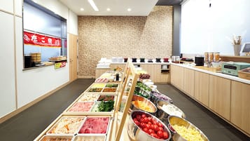 Un buffet proposant une variété de plats, un comptoir avec des boissons et un mur décoré d’un motif en arrière-plan.