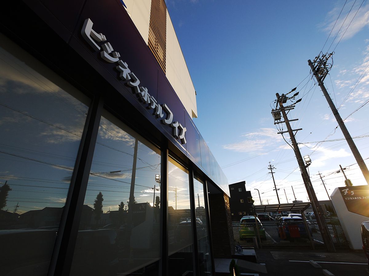 Un edificio con ventanas amplias y un cartel con caracteres japoneses.