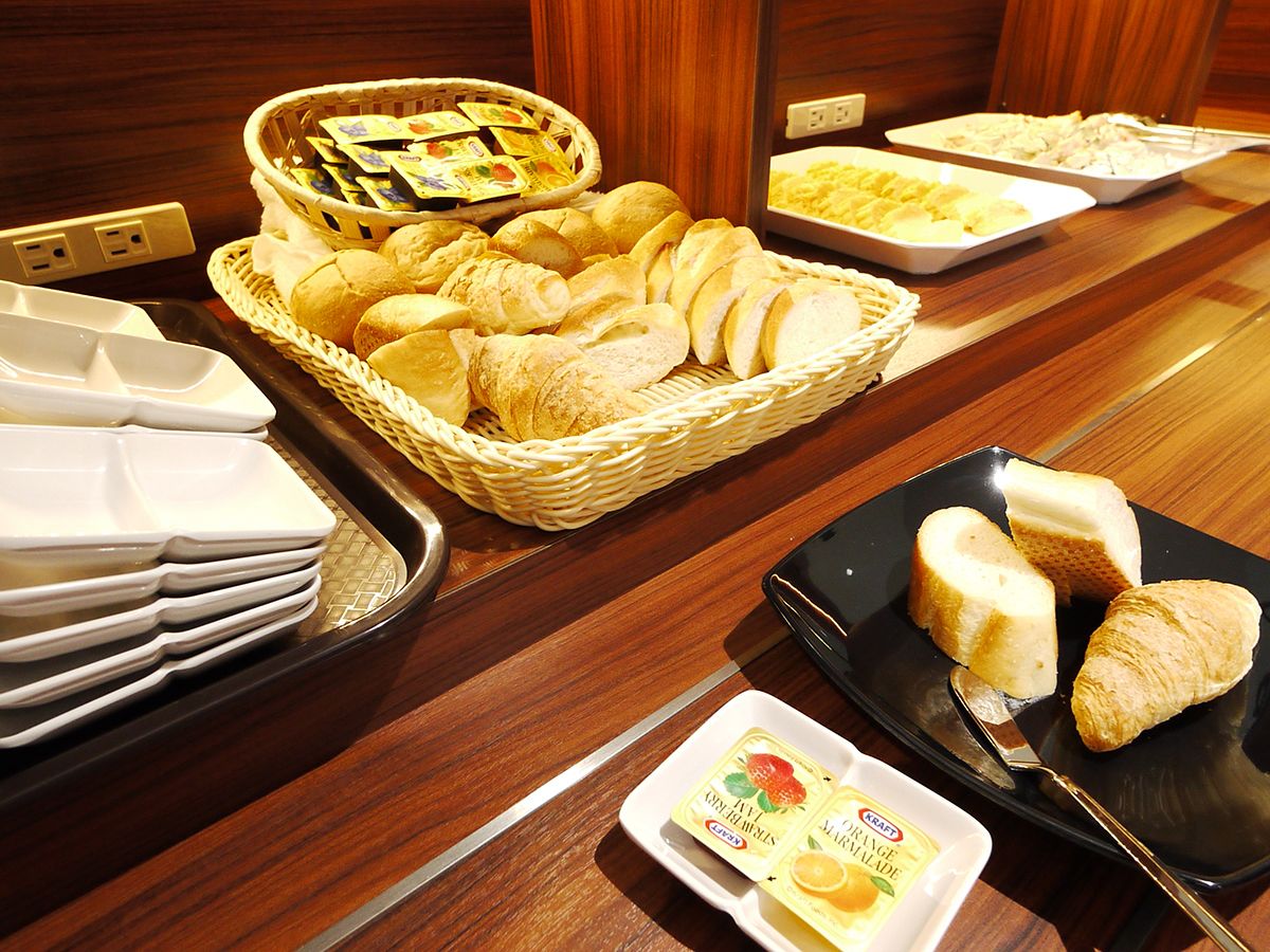 Un buffet proposant du pain, des viennoiseries et diverses tartinades.