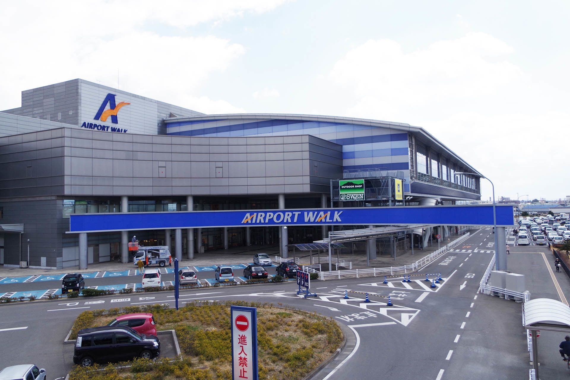 Una terminal de aeropuerto con un letrero azul para Airport Walk y un letrero para la Tienda Exterior.