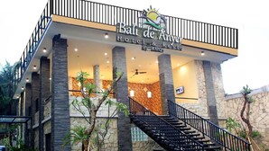 A hotel with a modern design, featuring a prominent entrance with a staircase and a sign that reads "Ball de Anyer Hotel & Restaurante." - Bali De Anyer Hotel and Restaurant (Carita)