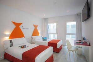 Une chambre d’hôtel avec deux lits, un bureau, une chaise et un téléviseur.