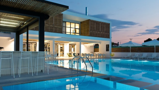 Un hôtel moderne doté d’une piscine, d’un espace extérieur aménagé et d’une zone couverte.