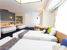 Habitación de hotel con dos camas, una mesa redonda, un espejo y una ventana.