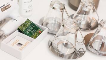 A hotel minibar with a Panasonic phone, a bottle of Japanese tea, and several glass carafes.