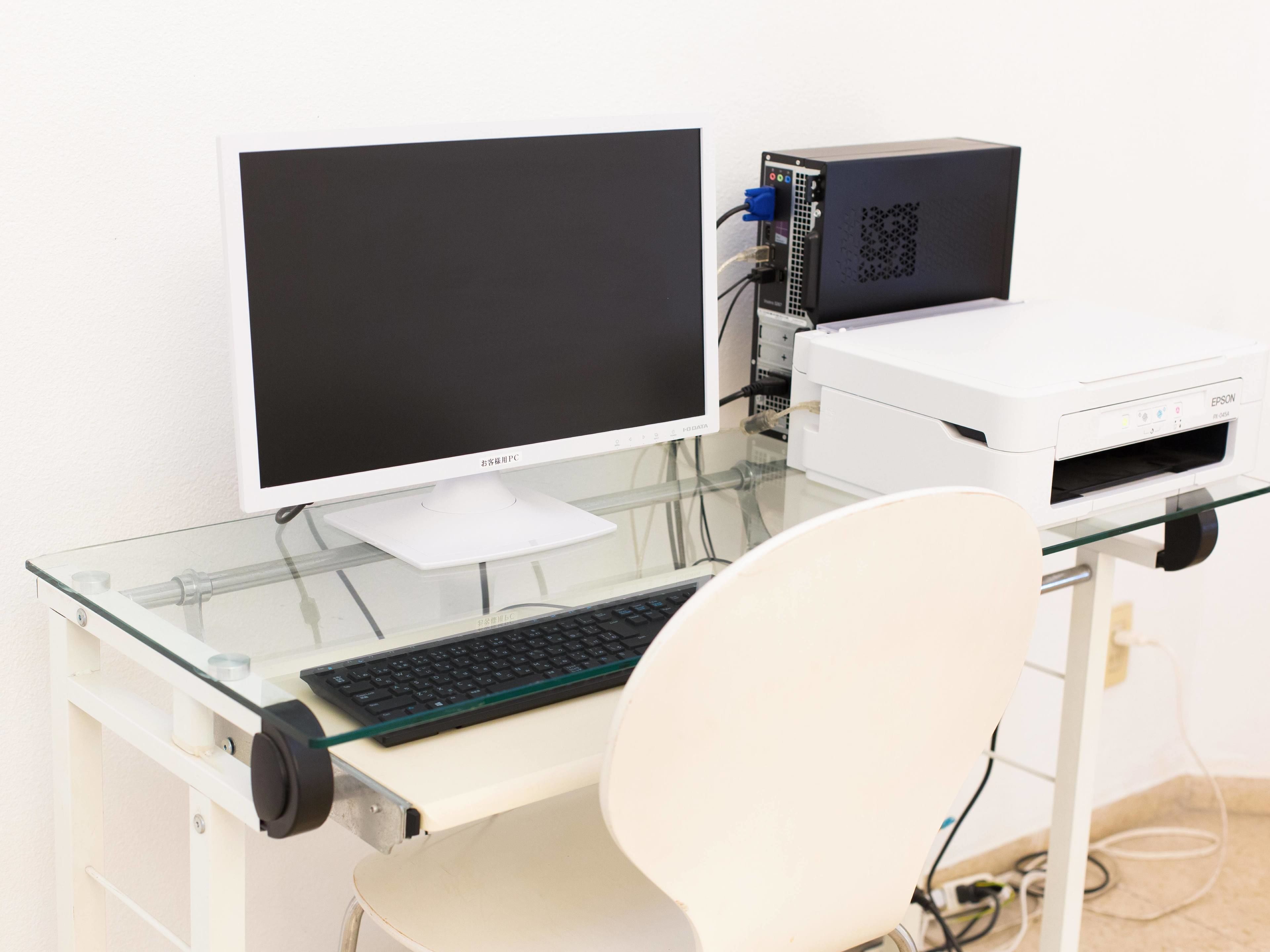Escritorio con monitor, teclado e impresora.