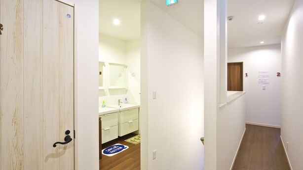 Un pasillo que conduce a un baño con lavamanos y espejo.
