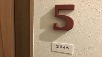 A wooden door with a wall number '5' and a sign with Japanese characters.