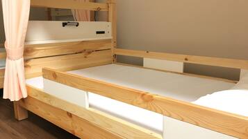 A wooden bunk bed with a white mattress and drawers underneath.