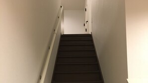 Una escalera con escalones de madera y paredes blancas.