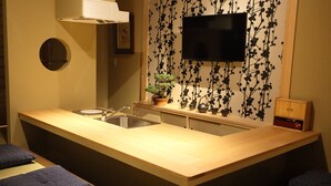 A compact kitchen with a wooden countertop, a sink, and a small potted plant. - Murasakino Uan (Kyoto)