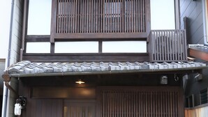 A traditional Japanese house with a wooden gate, a small balcony, and a tiled roof. - Murasakino Uan (Kyoto)