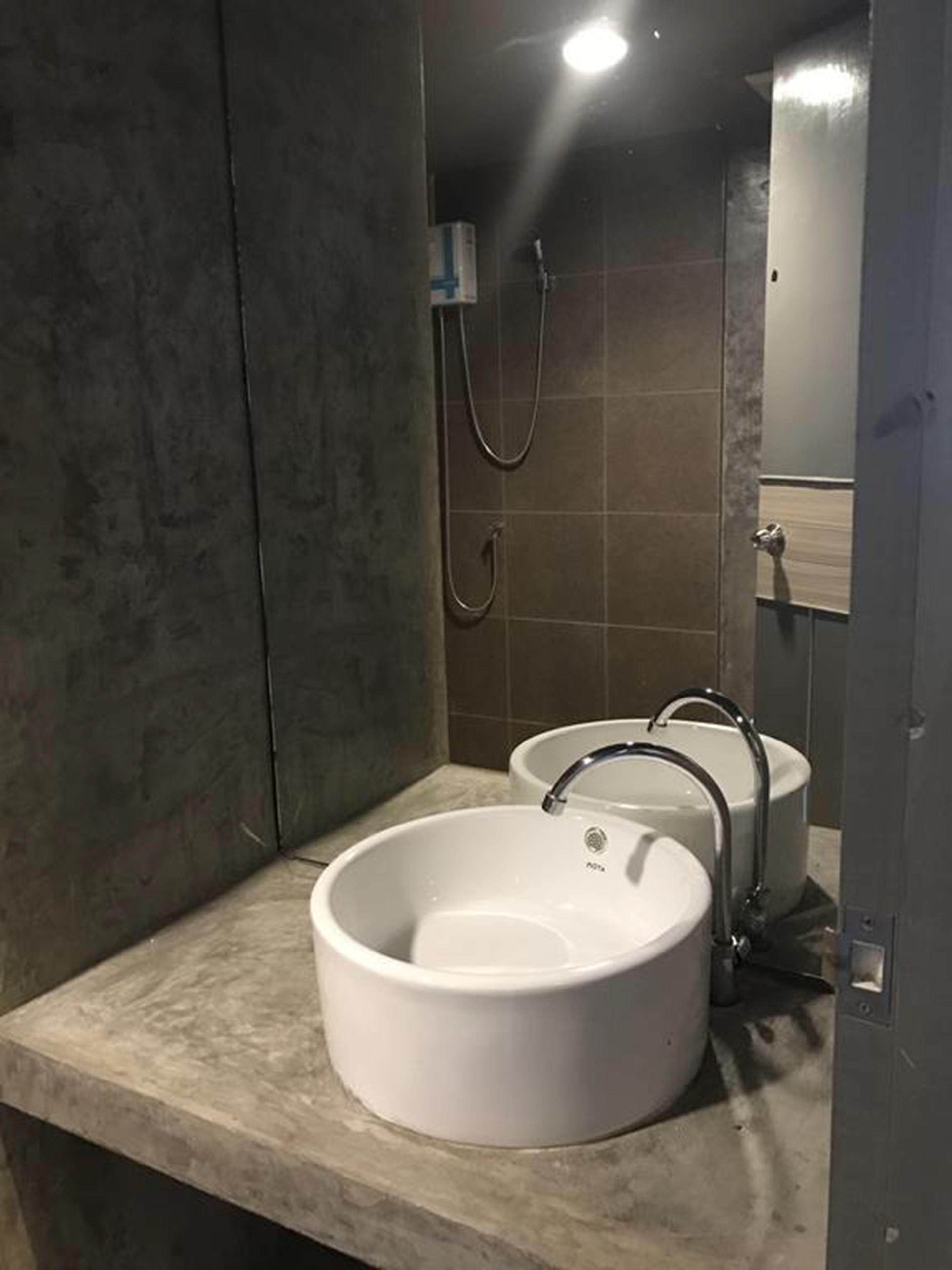 A bathroom with two sinks, a shower, and a mirror.
