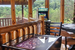 A wooden deck with a table and chairs, a card game table, and a slot machine.