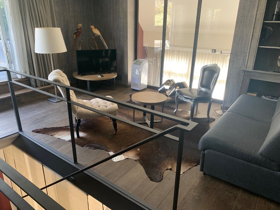 Un salon moderne comprenant un canapé, une table basse, un téléviseur et une machine à café.