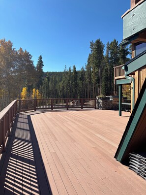 A wooden deck with a metal railing, surrounded by trees and a clear sky. - Specializing in Micro Weddings and Corporate Retreats. Large meeting event space (Breckenridge)