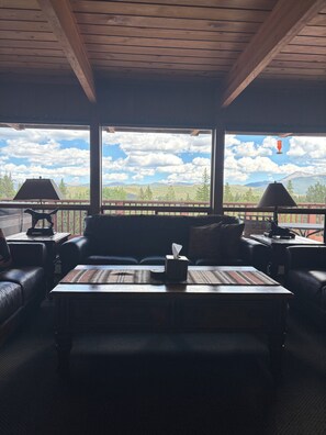 A room with a wooden ceiling, a sofa, a coffee table, and a view of mountains through large windows. - Private Chef included for Breakfast and Dinners.  Meeting room, ultimate privacy (Breckenridge)