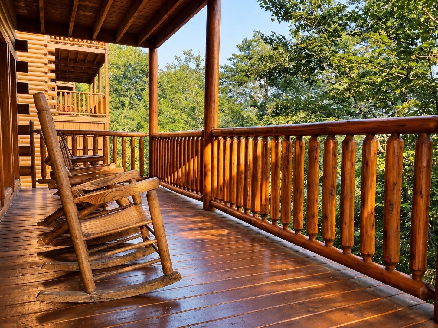 Une terrasse en bois avec une rambarde, une chaise berçante et un escalier menant à un niveau supérieur.