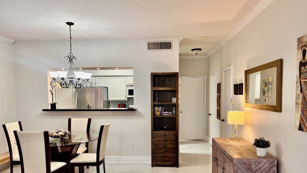 A modern dining area with a chandelier, a wooden sideboard, and a bookshelf. - Energy Corridor - long term rental. Utilities included!! (Houston)